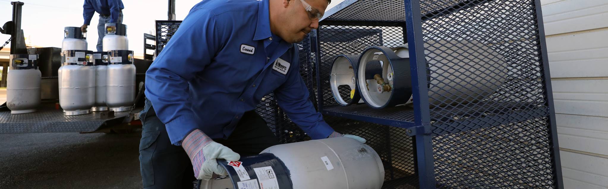 Hino Gas technician connecting and pressure testing propane cylinders on a service truck